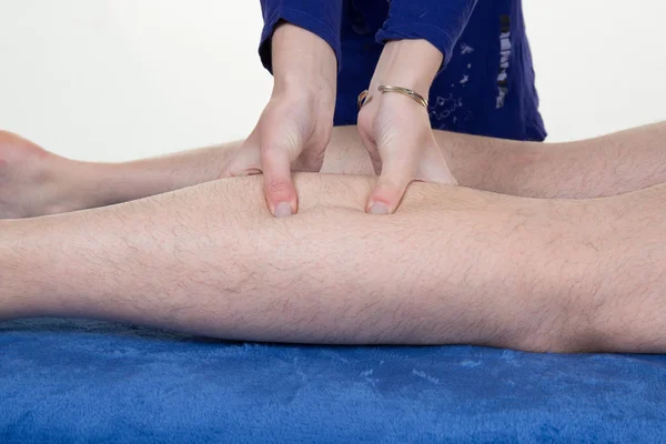 Hands massaging human calf muscle.Therapist applying pressure on male leg.