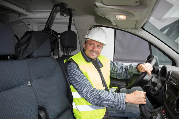 Construction worker, wearing a white helmet in a car driving