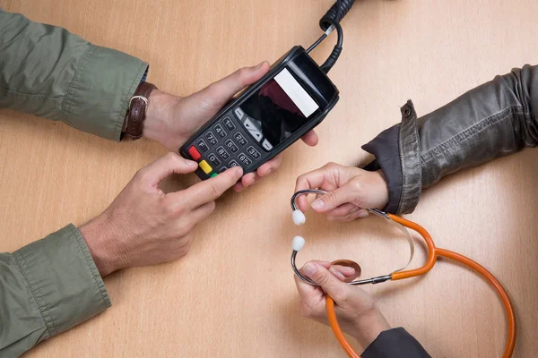 Doctor accepting payment through credit card from customer