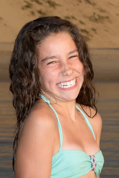 Young girl laughing and smiling at the beach