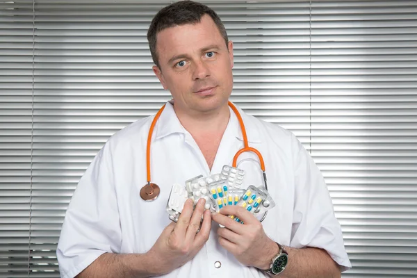 Portrait of cheerful doctor with several blister packs