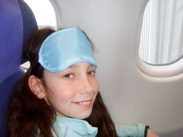 Little girl with  sleep eye mask on the plane