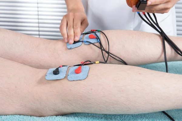 Therapist placing lots of electrodes on body