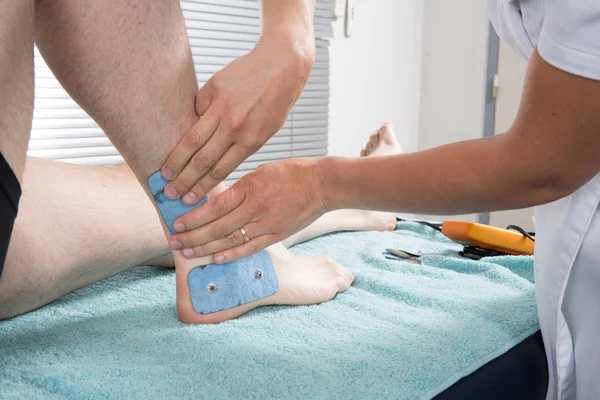 Therapist placing lots of electrodes on body