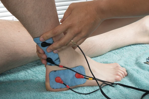 Therapist placing lots of electrodes on body