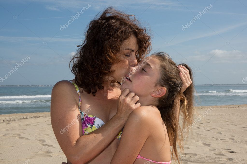 Две малышки ласкаются на пляже