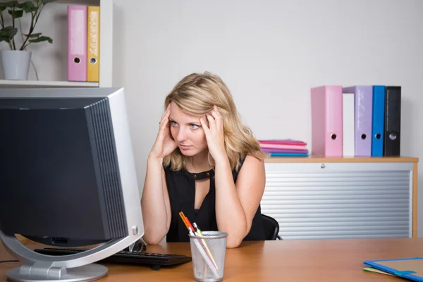 Woman at her desk looking at the computer