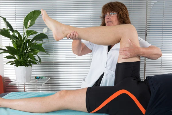 Patient at the physiotherapy doing physical therapy exercises with his therapist