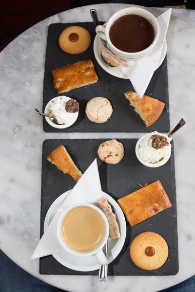 Cup of coffee and tasty cookies and cakes on grey background