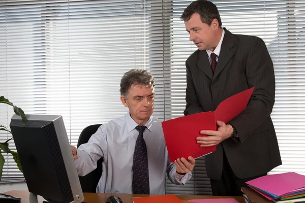 Two business people working at office looking at documents