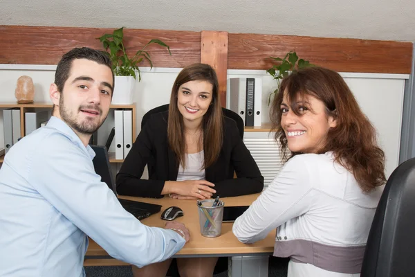 Couple with an insurance agent or investment adviser as he sits in a meeting at office