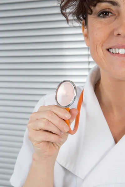 Close up of young female doctor with stethoscope on foreground. Cut out of face isolated on black background