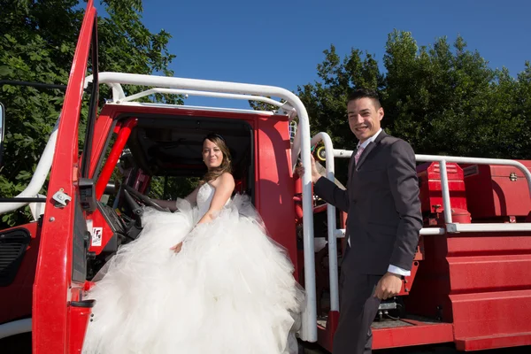 Beautiful and happy wedding couple on fire truck