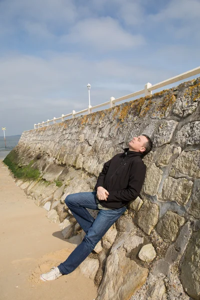Man breathing deep fresh air outdoors with a blue sky in the background