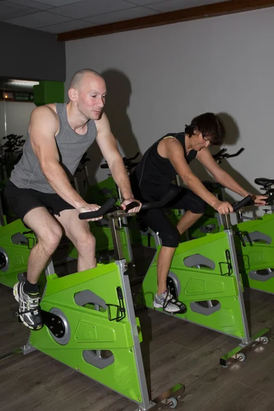 Fitness people with instructor at gym - biking concept