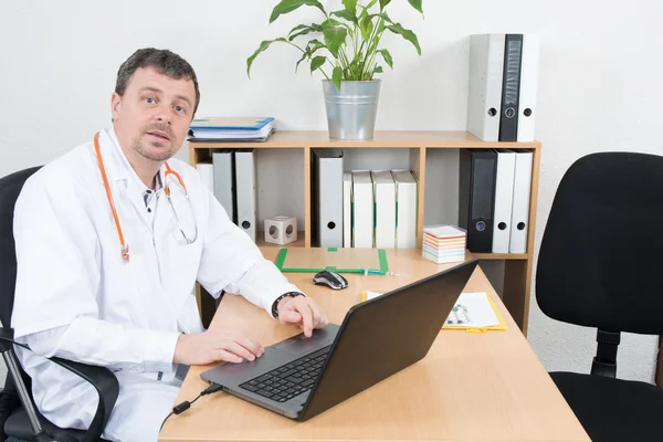 Confident doctor typing on his laptop in the office