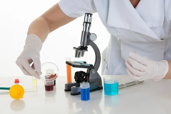 Scientist with microscope  making research in clinical laboratory