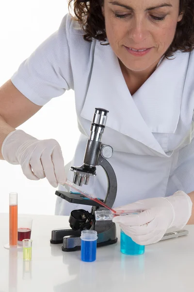 Female medical or scientific researcher using her microscope in a laboratory.