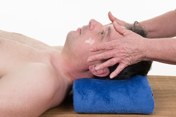 Side view of a man receiving a head massage at health spa