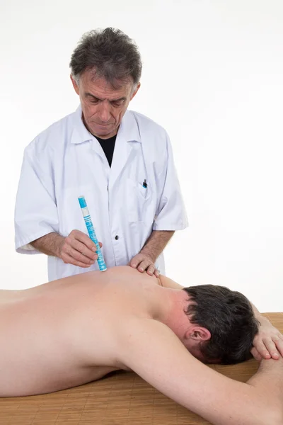 Alternative medicine therapist doing moxa treatment on his client