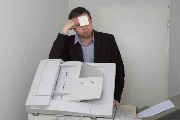 Man near copier with a paper out of order on his face