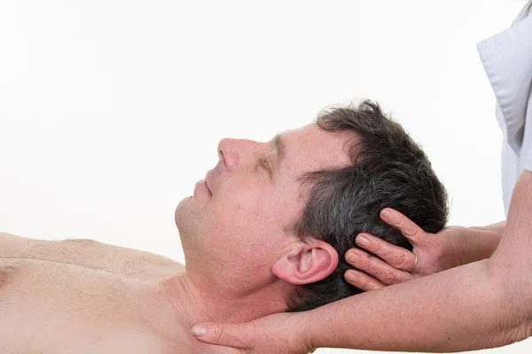 Masseur doing neck massage on man in the spa salon.