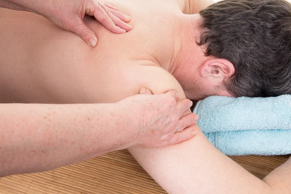 Masseur doing massage on man body in the spa salon.