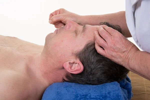 Detail of man receiving an acupuncture needle therapy