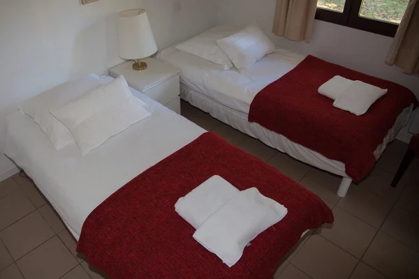 Spacious, white hotel room with two single beds