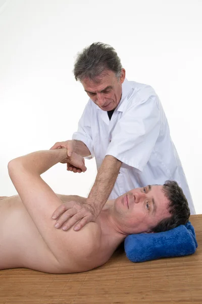 Masseur applying advanced massage in order to relax patient\'s muscles.