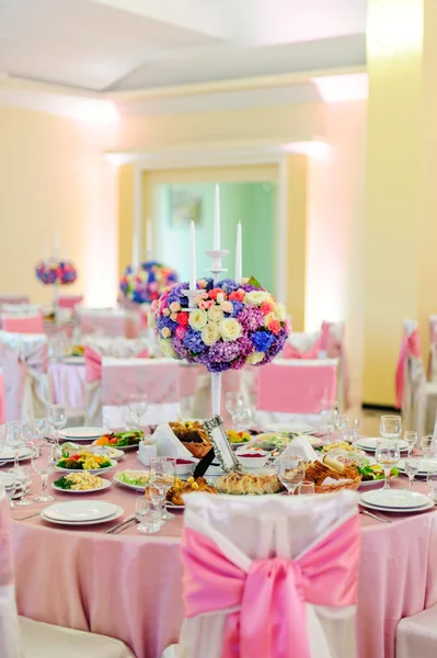 Decorated table with beautiful flowers and a lot of dishes in the restaurant