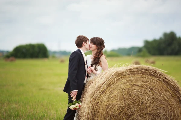 Bride and groom near hay