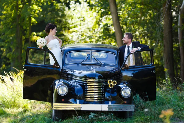 A wedding couple with old car