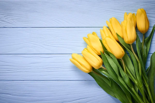 Mothers Day background.Tulips bouquet on blue wood