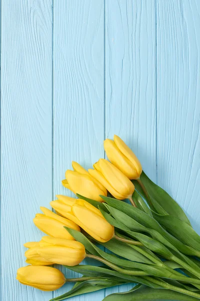 Mothers Day background.Tulips bouquet on blue wood