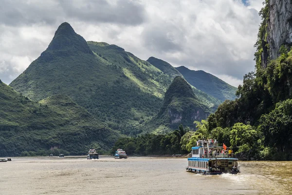 Guilin, China - circa July 2015: Cruise boat sails between karst mountains and limestone peaks of Li river in   China