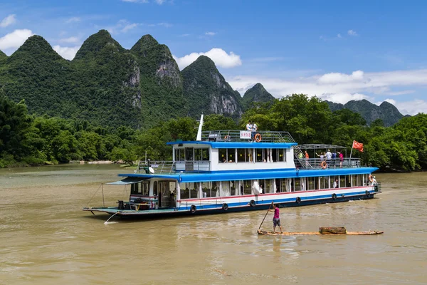 Guilin, China - circa July 2015: Cruise boat sails between karst mountains and limestone peaks of Li river in   China