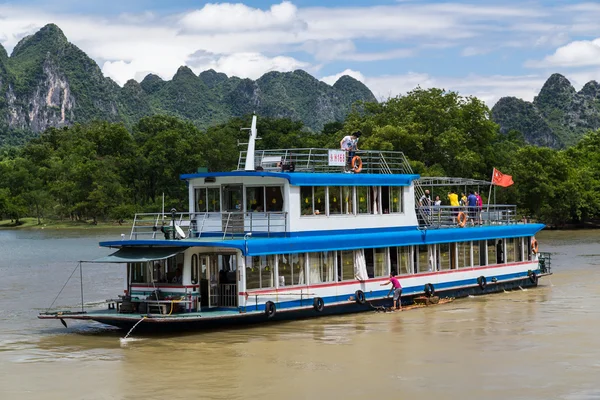 Guilin, China - circa July 2015: Cruise boat sails between karst mountains and limestone peaks of Li river in   China