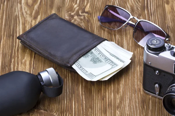 Gentlemanly set:  sunglasses, perfume, wallet, money,camera on wooden background