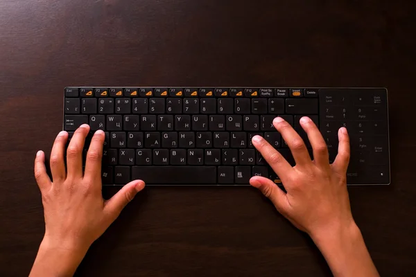 Black kids hands using keyboard.