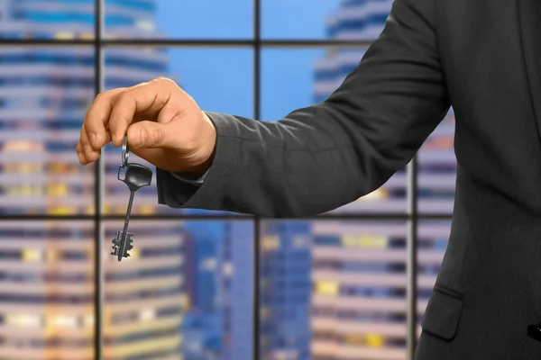 Hand of businessman holding key.