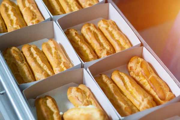 Boxes with eclairs on conveyor.