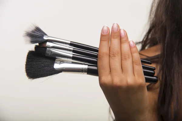 Nice lady is showing cosmetic brush set closeup.