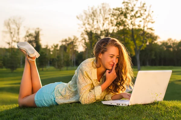 Girl works on the laptop in nature.