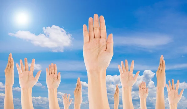 Diverse Raised Hands on sky background
