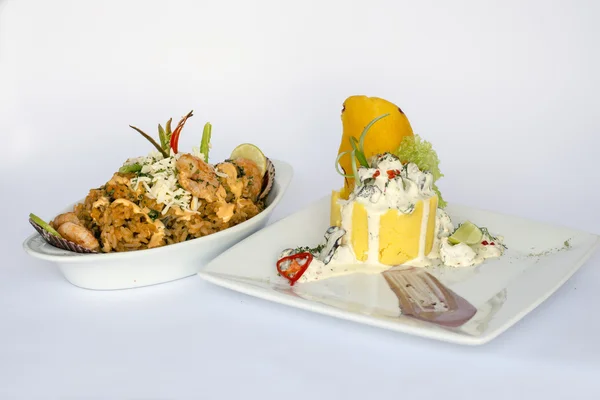 Peruvian Food: Causa Rellena, A smashed popatoes filled with crab meal and Rice with sea food. 2 dishes served as a main meal