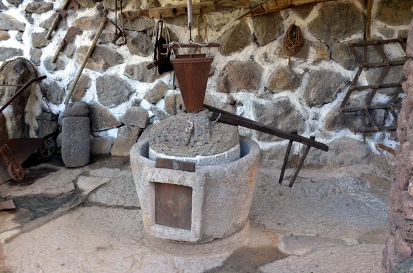 The ancient part of the oil press millstone ancient olive oil production machinery stone mill and mechanical press is found in close up in a rustic farm.