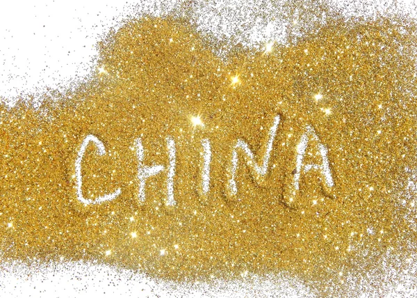 Inscription China on golden glitter sparkles on white background