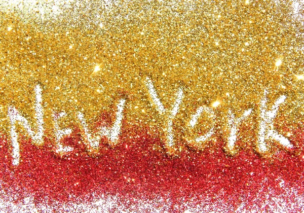 Inscription New York on golden and red glitter sparkle on white background