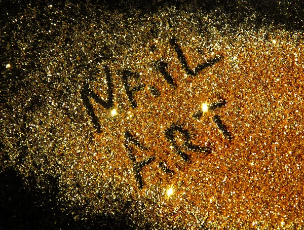 Inscription Nail Art on golden glitter sparkle on black background